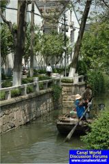Lady sculls while her man supervises, Suzhou, China